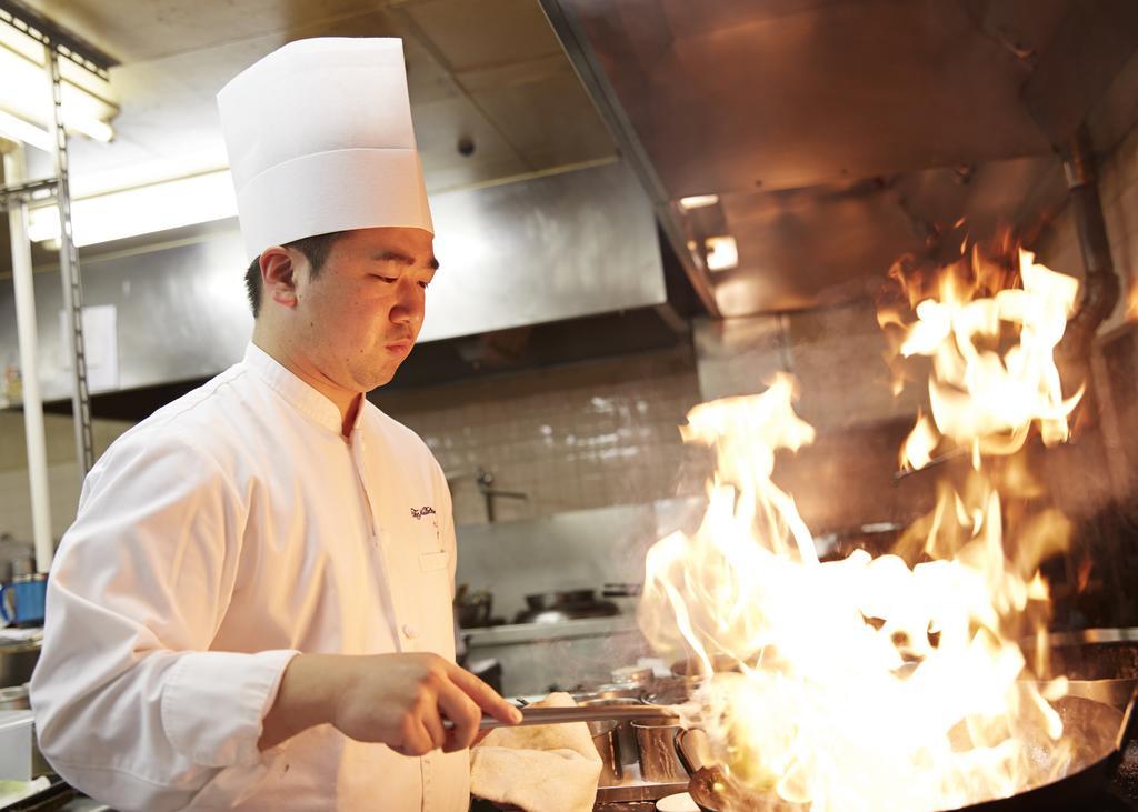 Hotel New Otani Hakata Фукуока Экстерьер фото A chef cooking with a wok